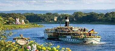 Ein Dampfschiff fährt auf der Elbe entlang der Elbschlösser.