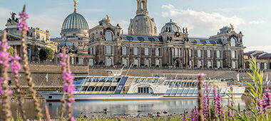 Ein Dampfschiff fährt auf der Elbe entlang der Elbschlösser.